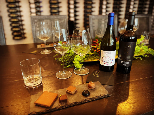 A table with wine glasses and chocolates on it.