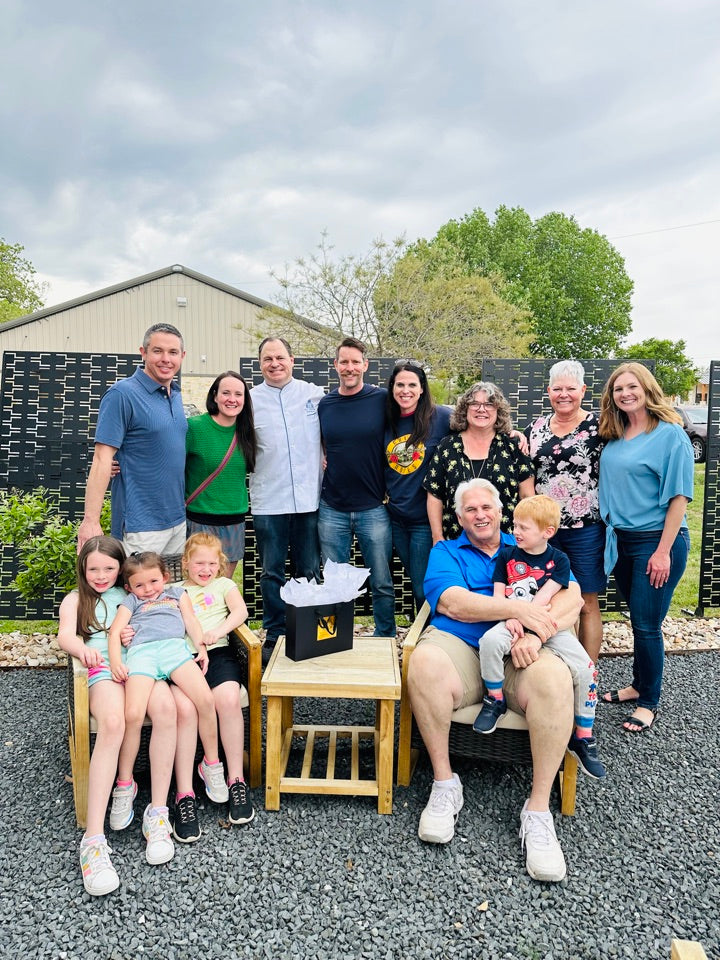 A group of people posing for a photo in a backyard.