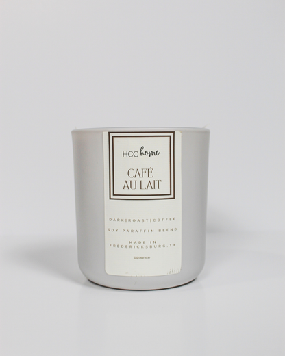 The HCC Home Candle - Cafe Au Lait by Hill Country Chocolate comes in a sleek silver jar and is hand poured in Fredericksburg, TX. This soy-paraffin blend candle captures the essence of rich dark roast coffee and is a genuine Texas-made product.