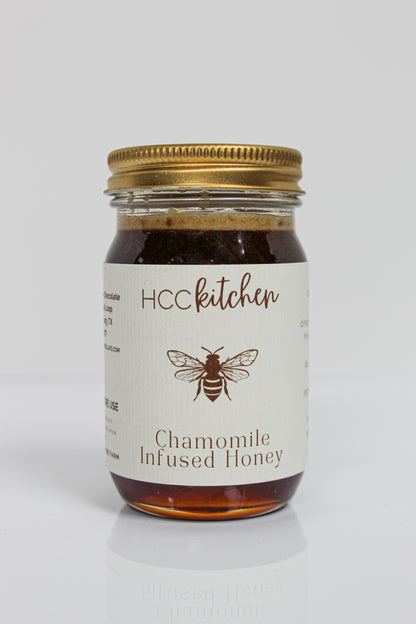 Jar of Hill Country Chocolate Chamomile Infused Honey with a gold lid, showcasing a bee illustration on the label against a plain white background. This soothing honey blends the delicate essence of chamomile with rich natural sweetness.