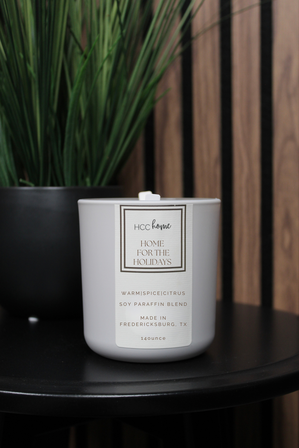 Light gray HCC Home Candle - Home for the Holidays in a white ceramic jar with a nostalgic scent of warm spice and citrus, a soy paraffin blend made in Fredericksburg, TX.