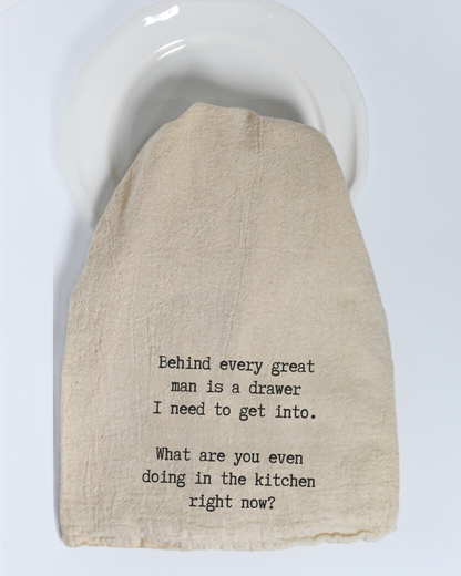 The “Behind every great man is...” Tea Towel by Hill Country Chocolate adds a playful touch to your kitchen with its witty black text on a beige cotton background, humorously referencing the need to get into a drawer behind someone. Made from natural materials, this eco-friendly kitchen towel combines practical use with lighthearted charm—perfect for any cooking space.